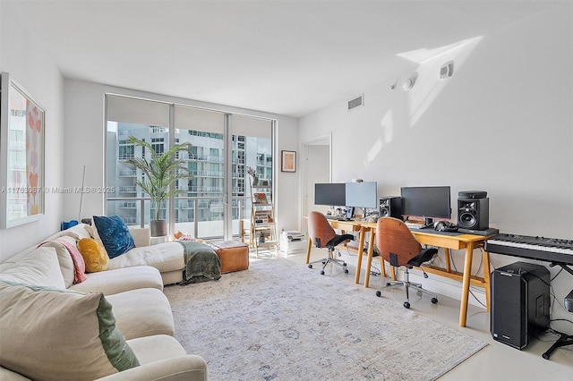 office featuring visible vents, a healthy amount of sunlight, and expansive windows