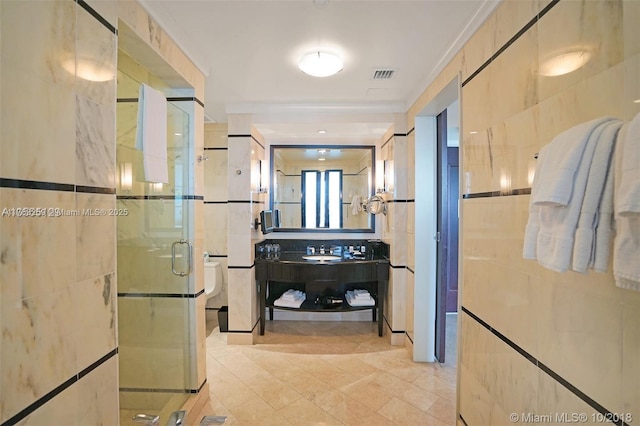 bathroom with tile walls, visible vents, and a shower stall