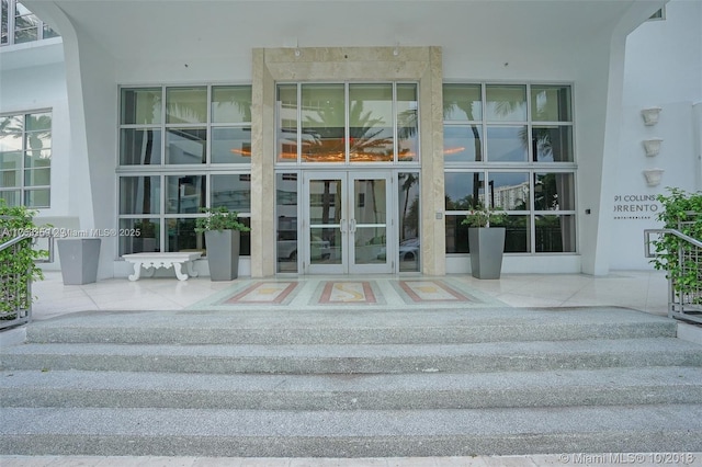 entrance to property featuring french doors and stucco siding