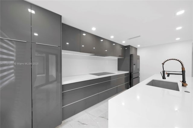 15712 SW 90th Ter, Miami, FL 33196 - kitchen with modern cabinets, a sink, black electric cooktop, light marble finish floors, and recessed lighting
