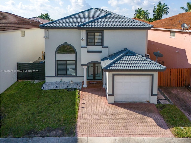 mediterranean / spanish house with stucco siding, decorative driveway, fence, and a tiled roof