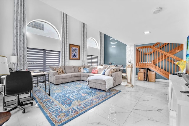 living room featuring plenty of natural light, marble finish floor, and a high ceiling