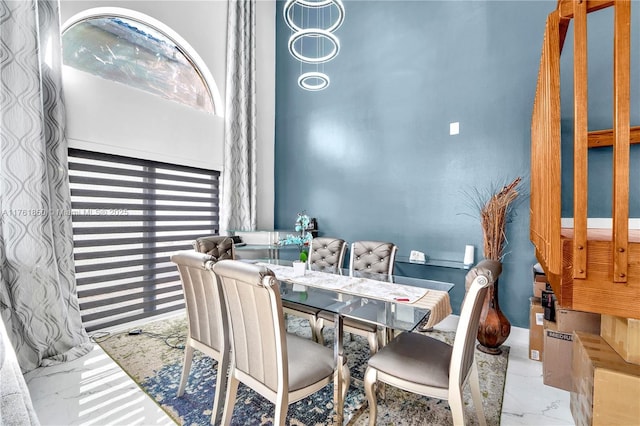 dining space featuring marble finish floor and baseboards