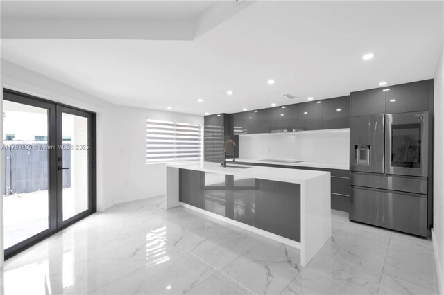 15712 SW 90th Ter, Miami, FL 33196 - kitchen featuring modern cabinets, a kitchen bar, a sink, stainless steel fridge, and light marble finish floors