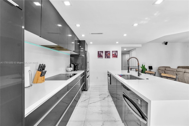 kitchen featuring black electric stovetop, a large island, marble finish floor, modern cabinets, and a sink