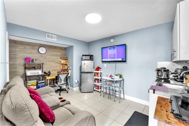 office featuring a sink, visible vents, baseboards, and light tile patterned floors