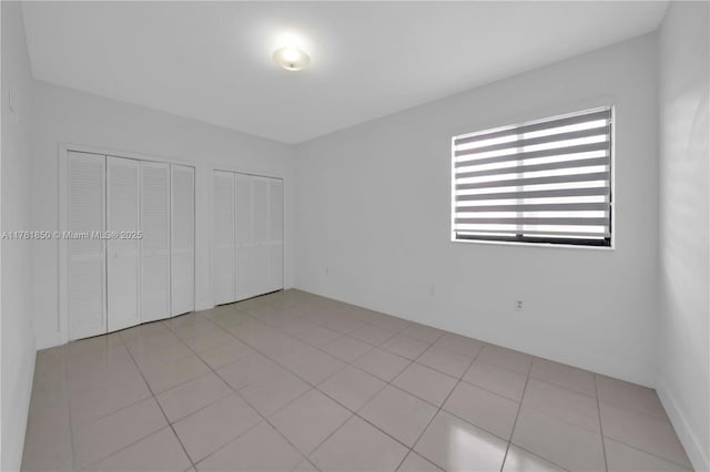 15712 SW 90th Ter, Miami, FL 33196 - unfurnished bedroom featuring multiple closets and light tile patterned floors