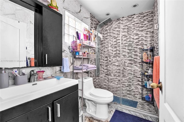 full bath featuring a shower stall, toilet, vanity, marble finish floor, and tile walls