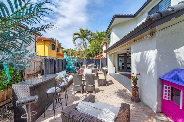 view of patio / terrace with outdoor dining area, french doors, fence, and outdoor dry bar