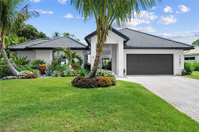 view of front of house featuring stucco siding, a garage, and a tiled roof