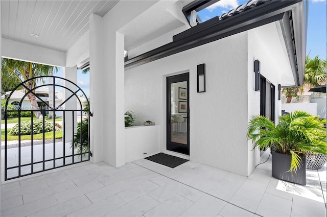 property entrance featuring stucco siding and a gate