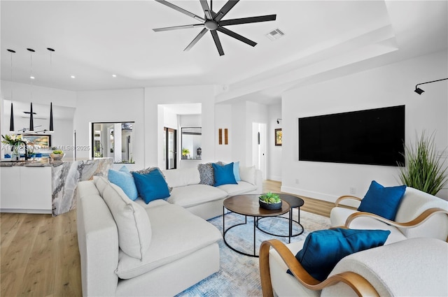 living area with visible vents, recessed lighting, light wood-style floors, baseboards, and ceiling fan