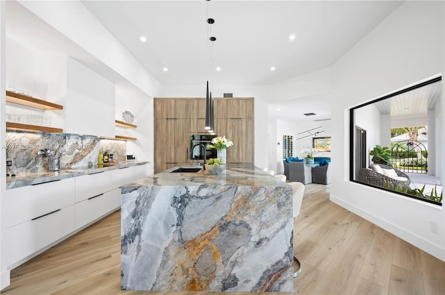 kitchen featuring backsplash, open shelves, a wood stove, modern cabinets, and a sink