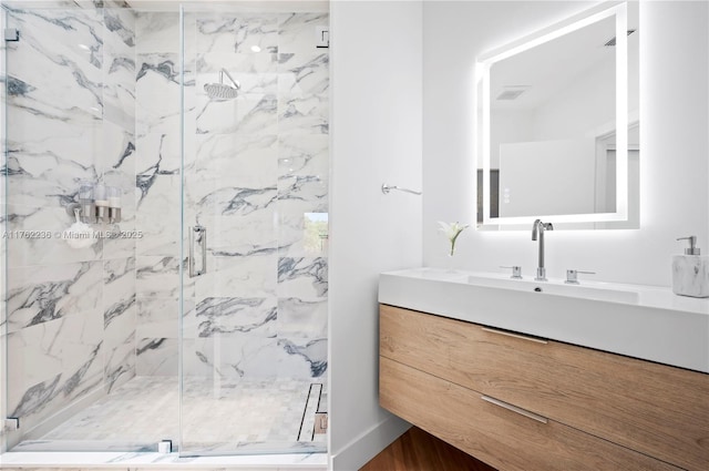 full bath with a marble finish shower and vanity