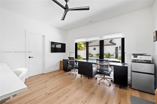 office space featuring baseboards, ceiling fan, and wood finished floors