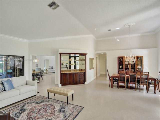 living room featuring visible vents, baseboards, ornamental molding, a notable chandelier, and a textured ceiling