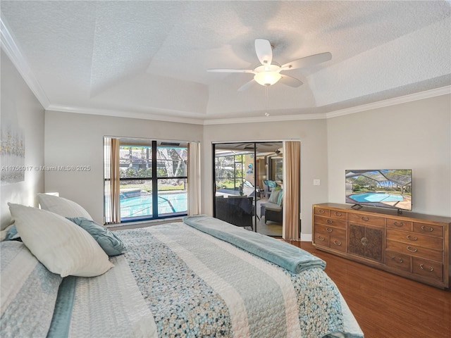 bedroom with wood finished floors, ornamental molding, a textured ceiling, a raised ceiling, and access to outside