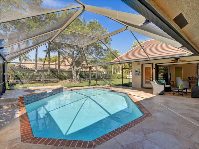 view of swimming pool with a patio area, a pool with connected hot tub, a lanai, and a ceiling fan