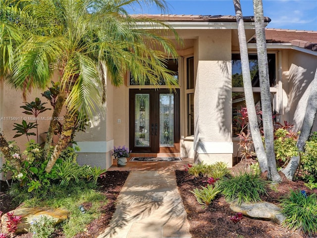 entrance to property featuring french doors and stucco siding