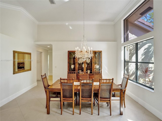 dining area with baseboards, crown molding, and an inviting chandelier