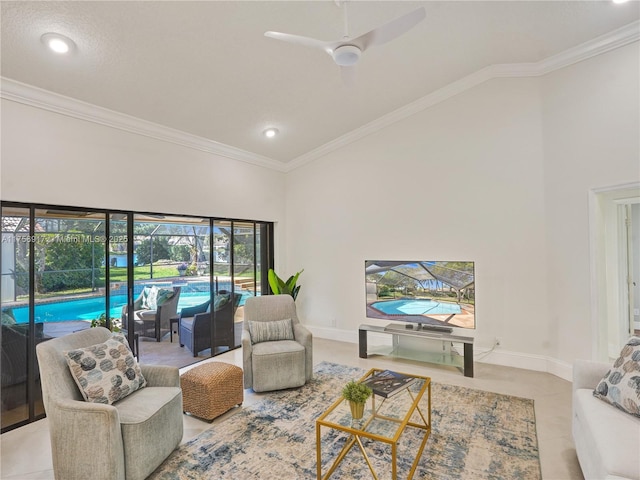 living area with crown molding, a high ceiling, and a ceiling fan