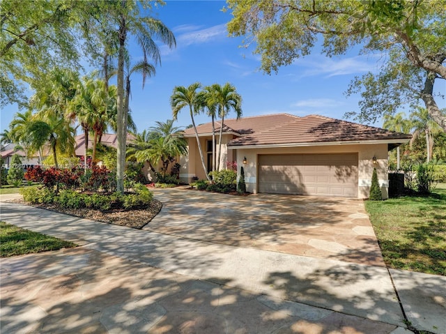 view of front facade featuring a tile roof, a garage, driveway, and stucco siding