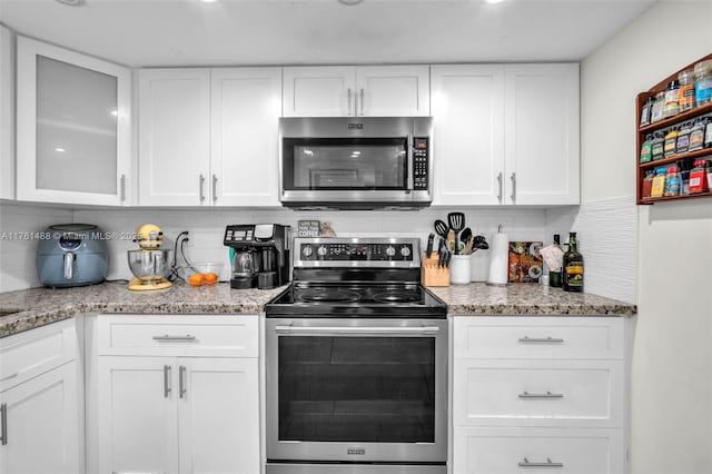 kitchen featuring backsplash, white cabinets, and appliances with stainless steel finishes