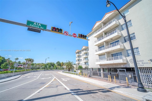 view of road with curbs, traffic signs, traffic lights, street lights, and sidewalks