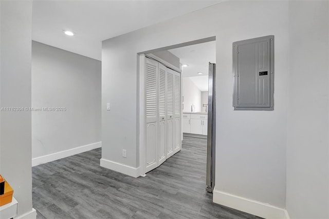 hallway with electric panel, recessed lighting, baseboards, and wood finished floors