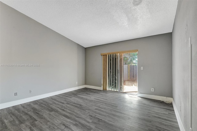 empty room with baseboards, dark wood-type flooring, and a textured ceiling