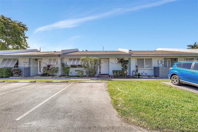 single story home with stucco siding, uncovered parking, and a front yard