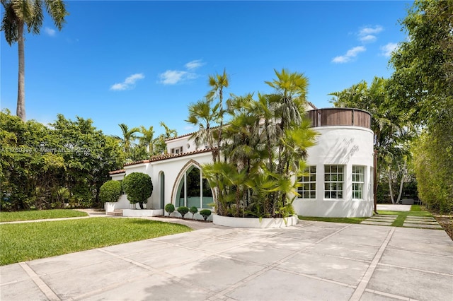 rear view of property with a yard and stucco siding