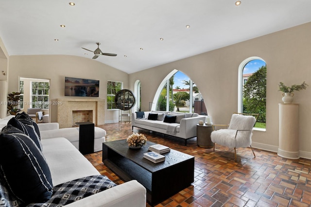 living room featuring baseboards, ceiling fan, a premium fireplace, vaulted ceiling, and recessed lighting