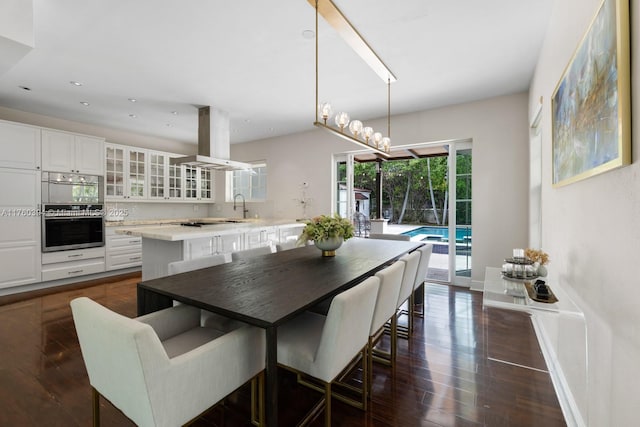 dining room featuring dark wood-style floors, recessed lighting, and baseboards