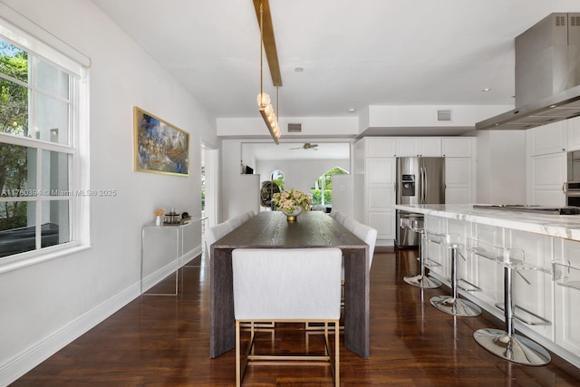 kitchen with white cabinetry, ventilation hood, plenty of natural light, and light stone counters