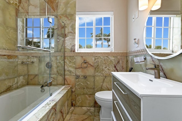 bathroom featuring vanity, tile walls, toilet, and plenty of natural light