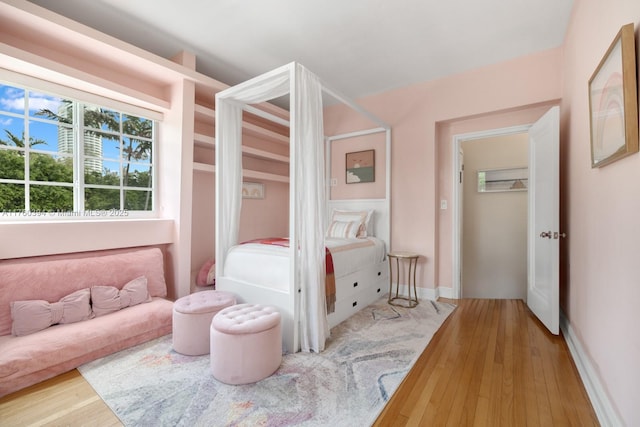 bedroom with baseboards and wood-type flooring