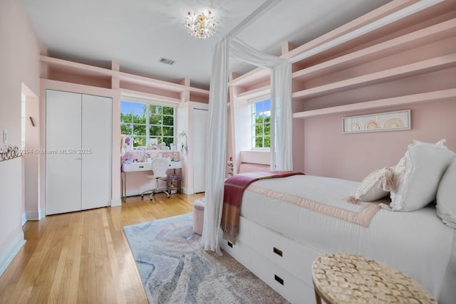 bedroom featuring visible vents and wood finished floors