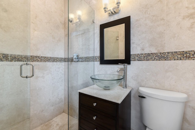 full bathroom featuring tiled shower, toilet, tile walls, and vanity