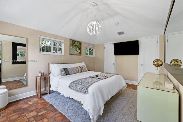 bedroom with baseboards, visible vents, an inviting chandelier, vaulted ceiling, and a closet