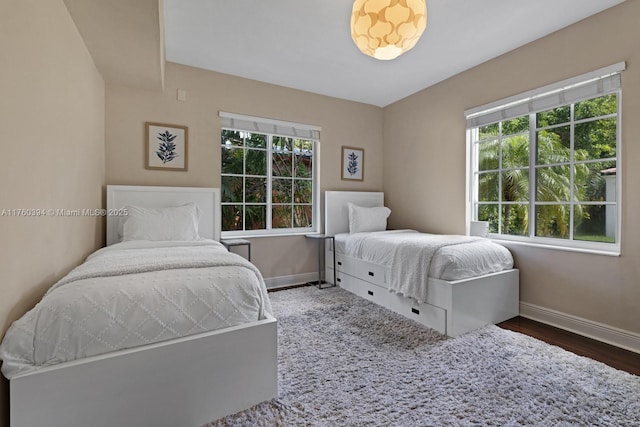 bedroom with wood finished floors and baseboards