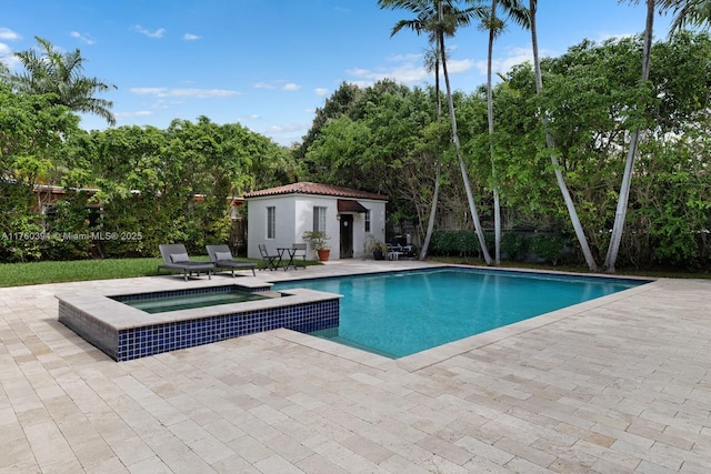 view of swimming pool featuring a storage structure, a patio, an outbuilding, and a pool with connected hot tub