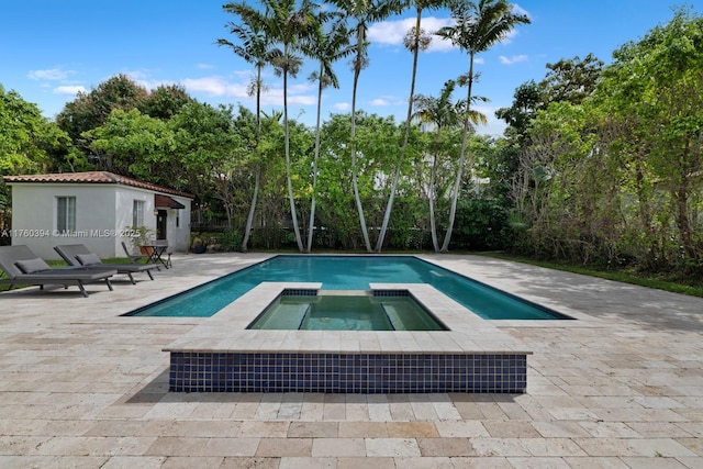 view of swimming pool featuring a patio and a pool with connected hot tub