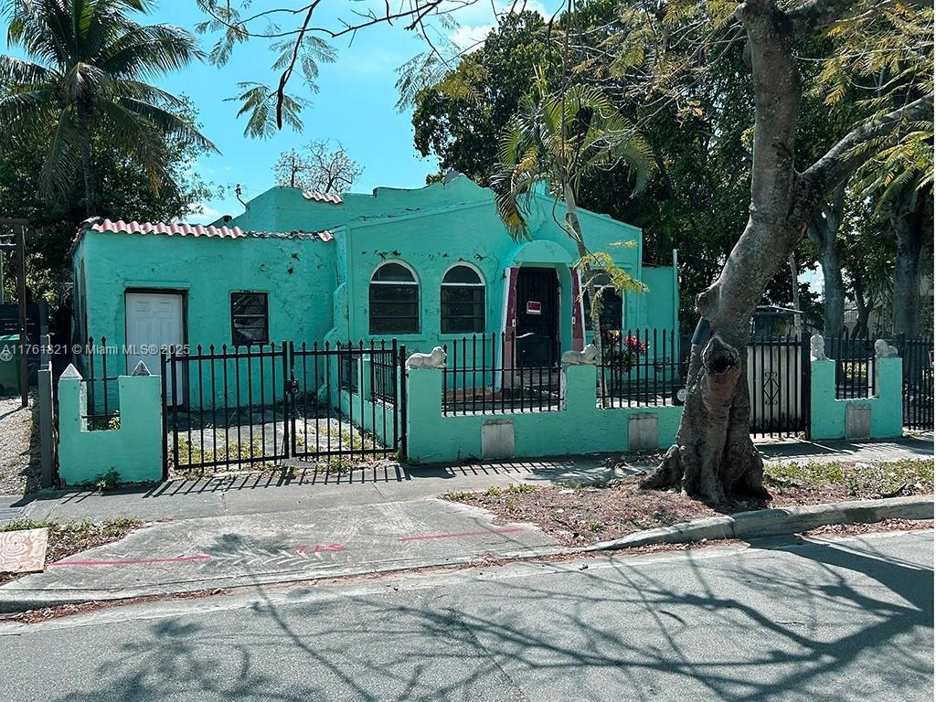 view of front of house with a gate, a fenced front yard, a tile roof, and stucco siding