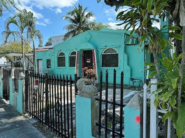 view of front of house featuring a gate, stucco siding, and fence