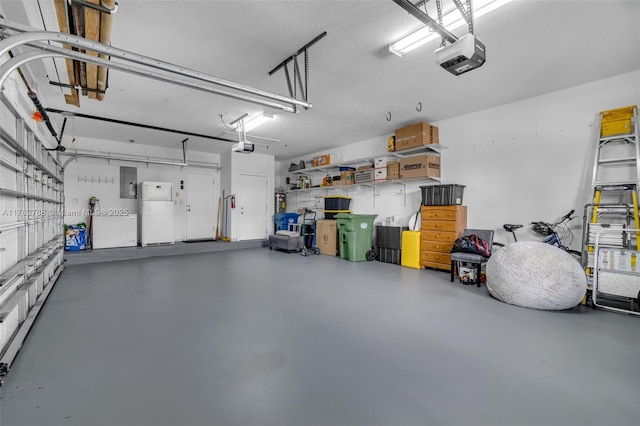 garage featuring electric panel, a garage door opener, and freestanding refrigerator