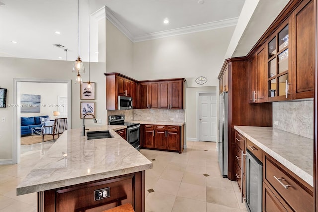 kitchen featuring ornamental molding, light stone counters, appliances with stainless steel finishes, and a sink