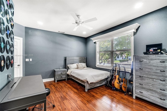 bedroom with baseboards, ceiling fan, dark wood-style flooring, and a textured wall