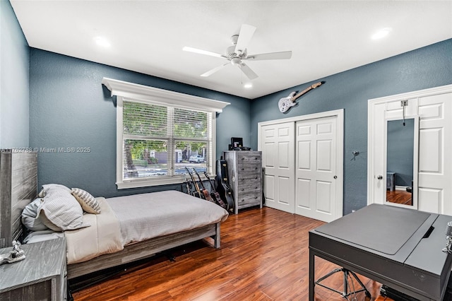 bedroom featuring wood finished floors, a ceiling fan, and a textured wall