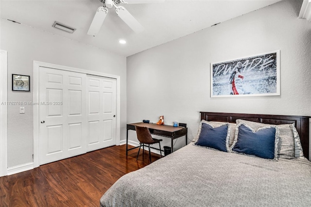 bedroom with a ceiling fan, wood finished floors, visible vents, baseboards, and a closet